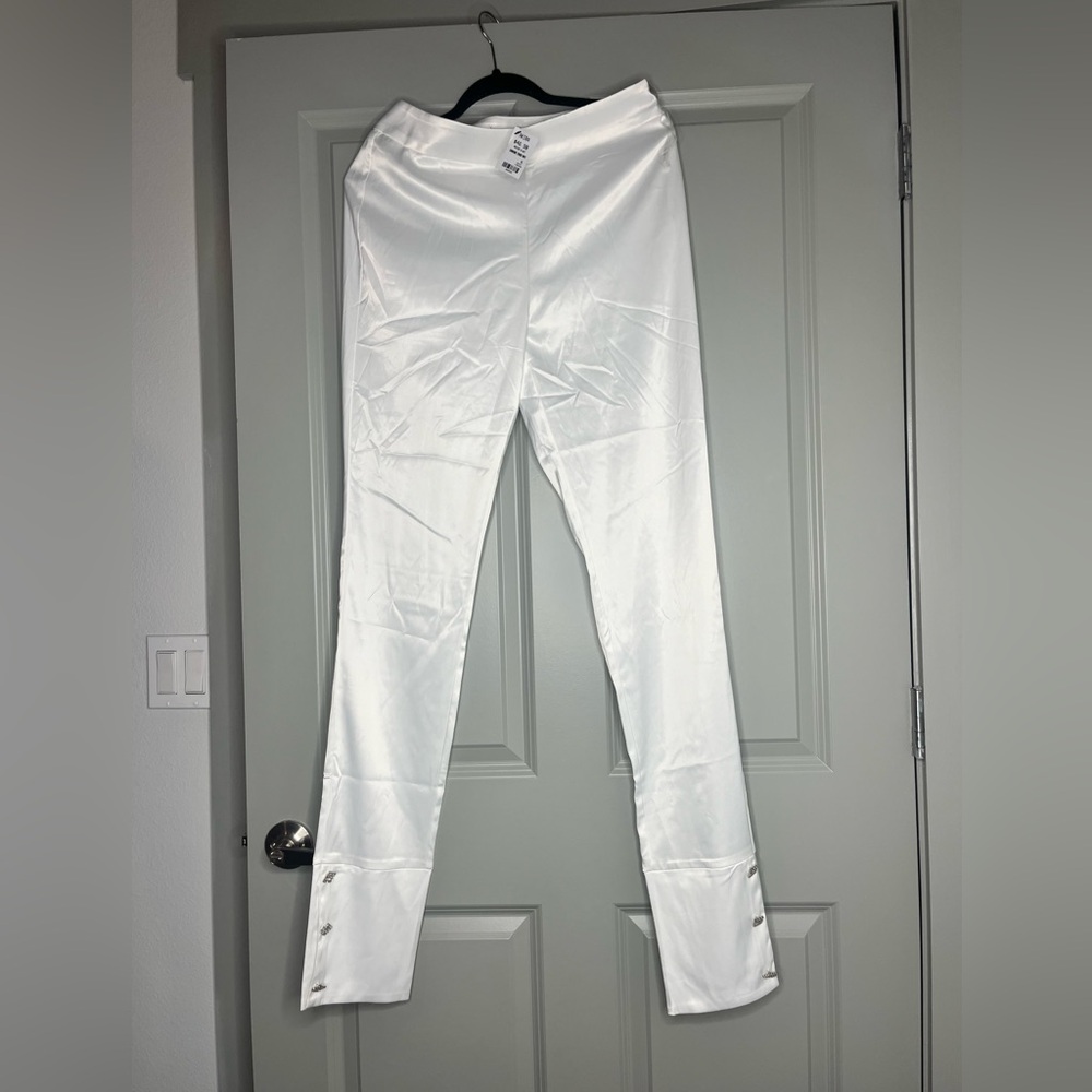 White Satin pants with rhinestones buttons in the bottom.